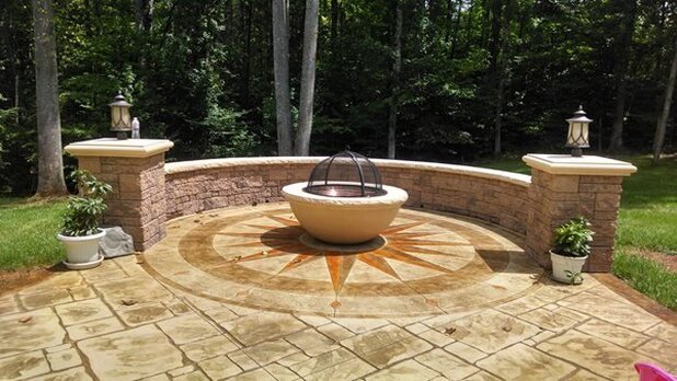 Beautiful decorative stamped concrete patio with wall and firepit
